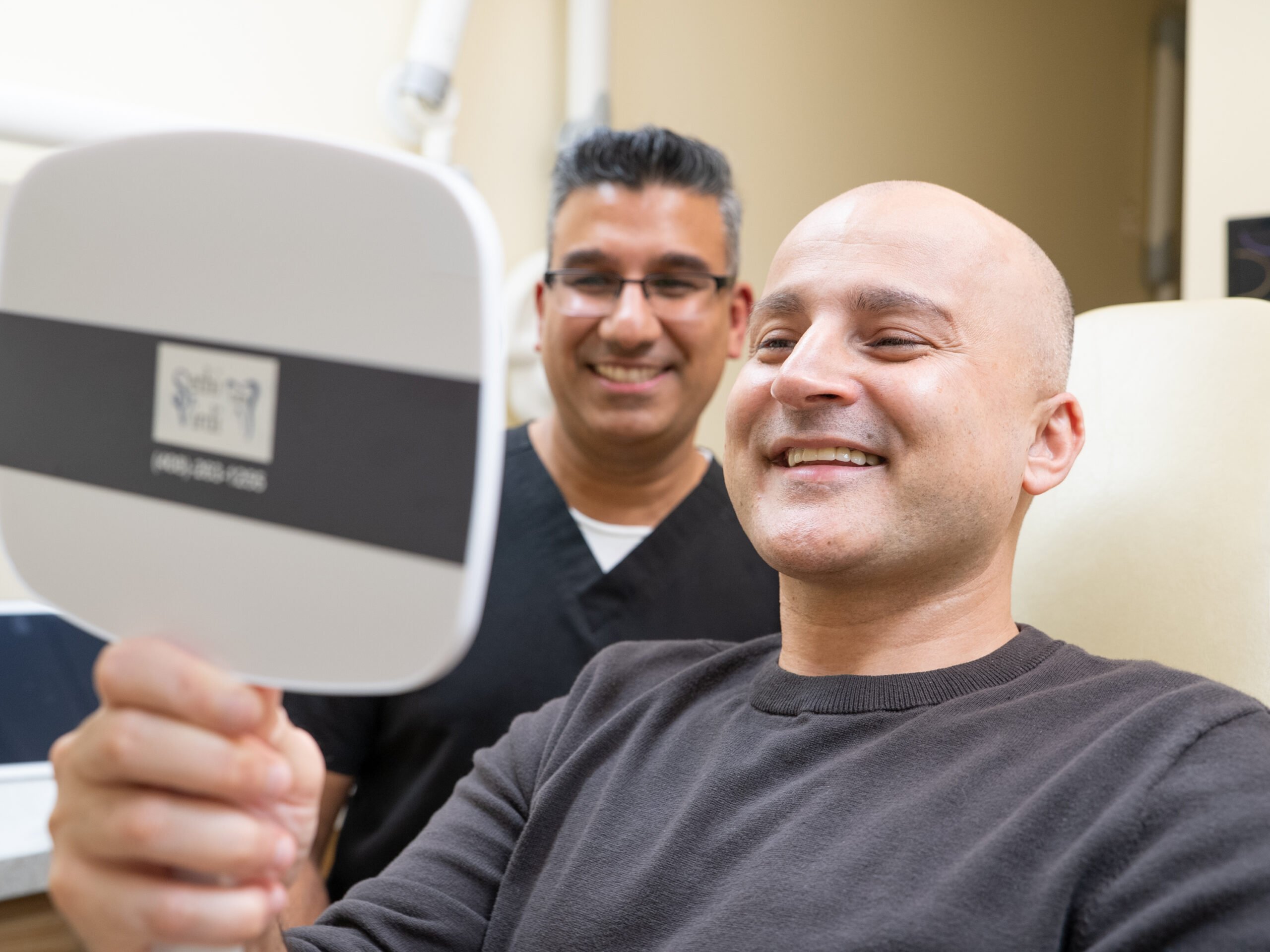 Dr. Virdi and smiling dental implant patient